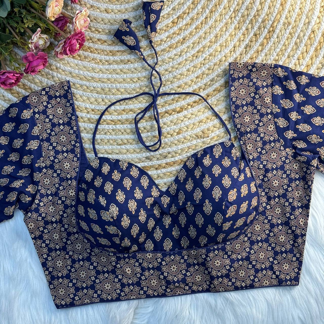 Navy blue and gold patterned top and pants on a textured surface flowers