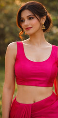 Woman wearing a bright pink traditional outfit with a blurred natural background